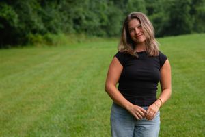 A casual outdoor portrait session in a lush green field on a summer day.