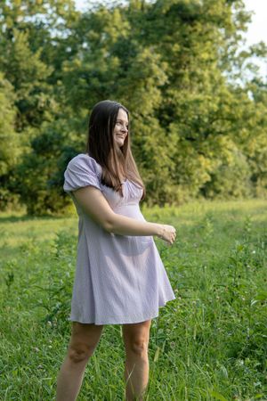 Person in light dress enjoying candid moments in sunny meadow.