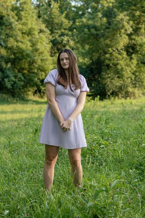 Casual outdoor photo sequence in flowing dress among green grass.