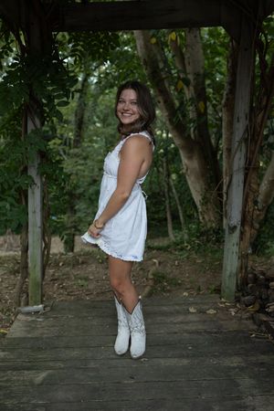 Dynamic poses captured on a rustic deck with white boots and flowing summer dress.