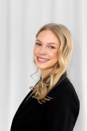 Three profile shots of someone with blonde wavy hair wearing a black blazer against a white background, smiling warmly.