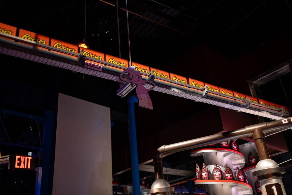 Indoor venue with colorful signage and lighting along the walls and ceiling.