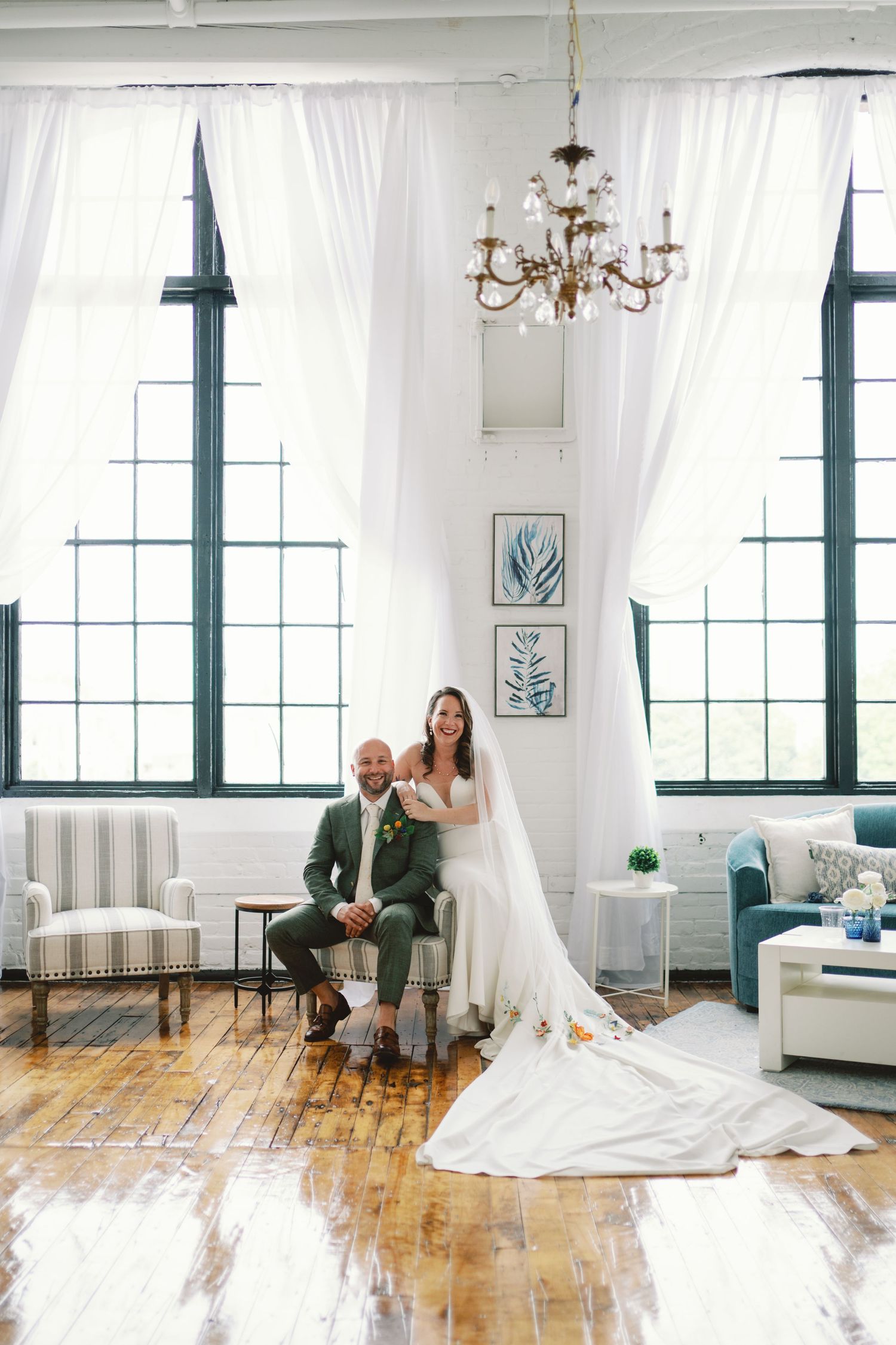 A series of elegant minimalist wedding portraits in an industrial loft space with white curtains and hardwood floors.