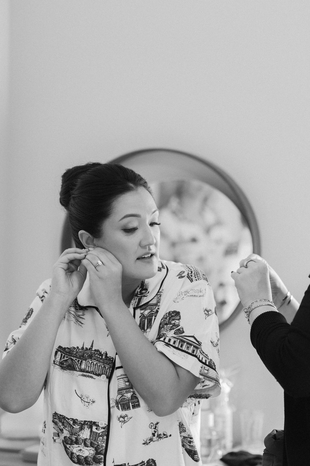 A sequence of candid photos showing someone applying makeup while getting ready in black and white.