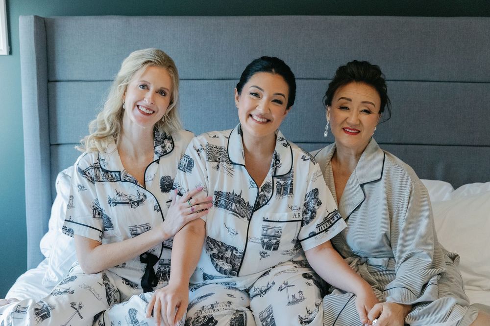 Wedding party members relax together in matching floral robes during pre-ceremony preparations.