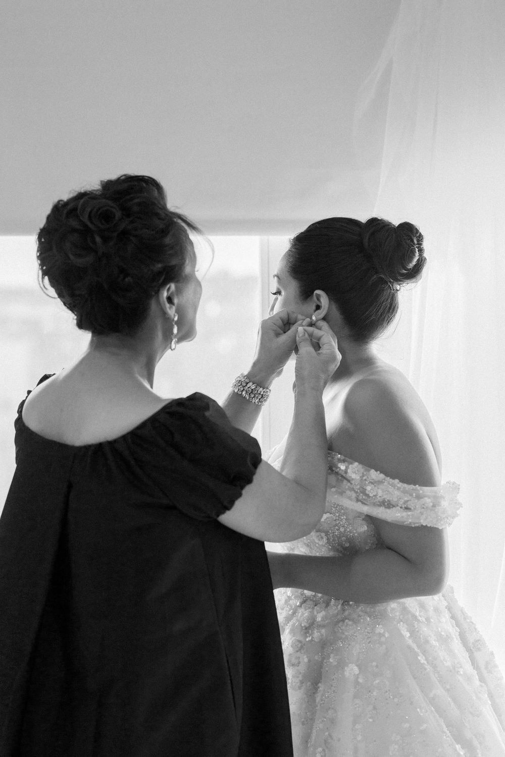 Behind-the-scenes wedding preparation moment captured in black and white.