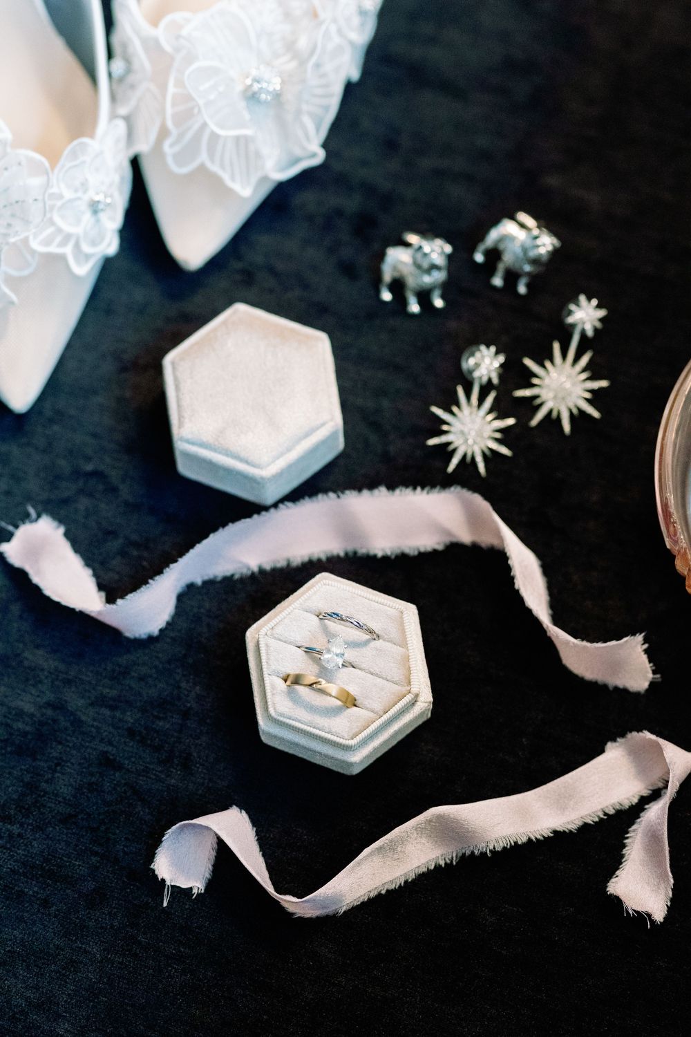 White and silver wedding accessories including hexagonal boxes and star decorations on a dark background.