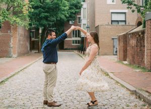 A sequence of romantic dance poses captured on a cobblestone street in front of brick buildings.