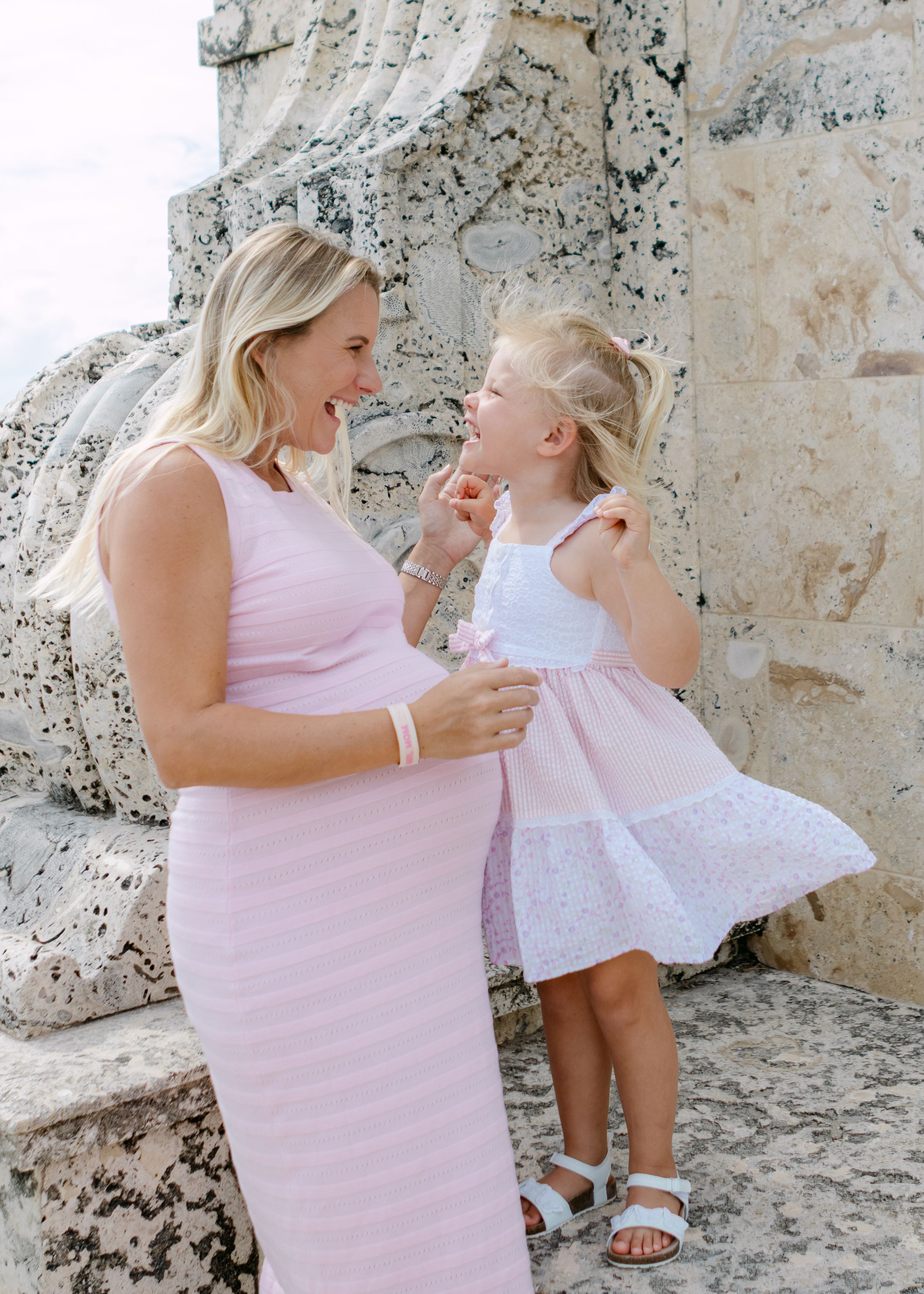 A family moment captured against a textured stone wall background.