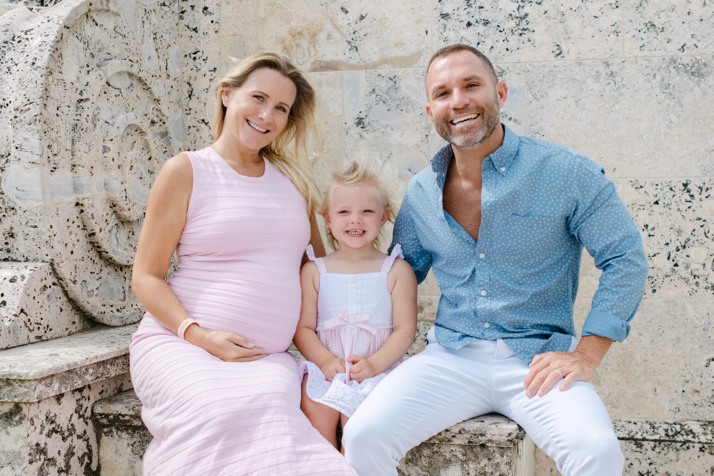 A family portrait session against a rustic stone backdrop.