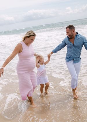 A family playing together in the ocean waves at the beach.
