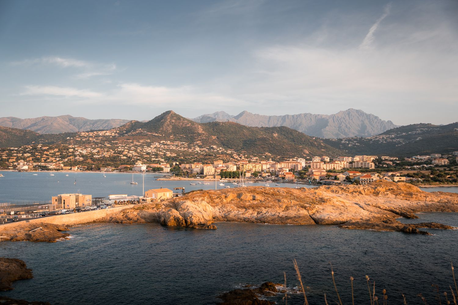 l'ile rousse, son port et les montagnes de la balagne en arrière plan au coucher du soleil