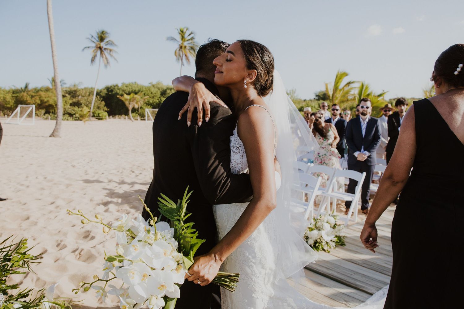A romantic moment between newlyweds during their beach wedding ceremony.