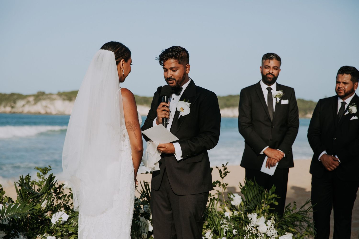 A seaside wedding ceremony with tropical flowers and ocean views.