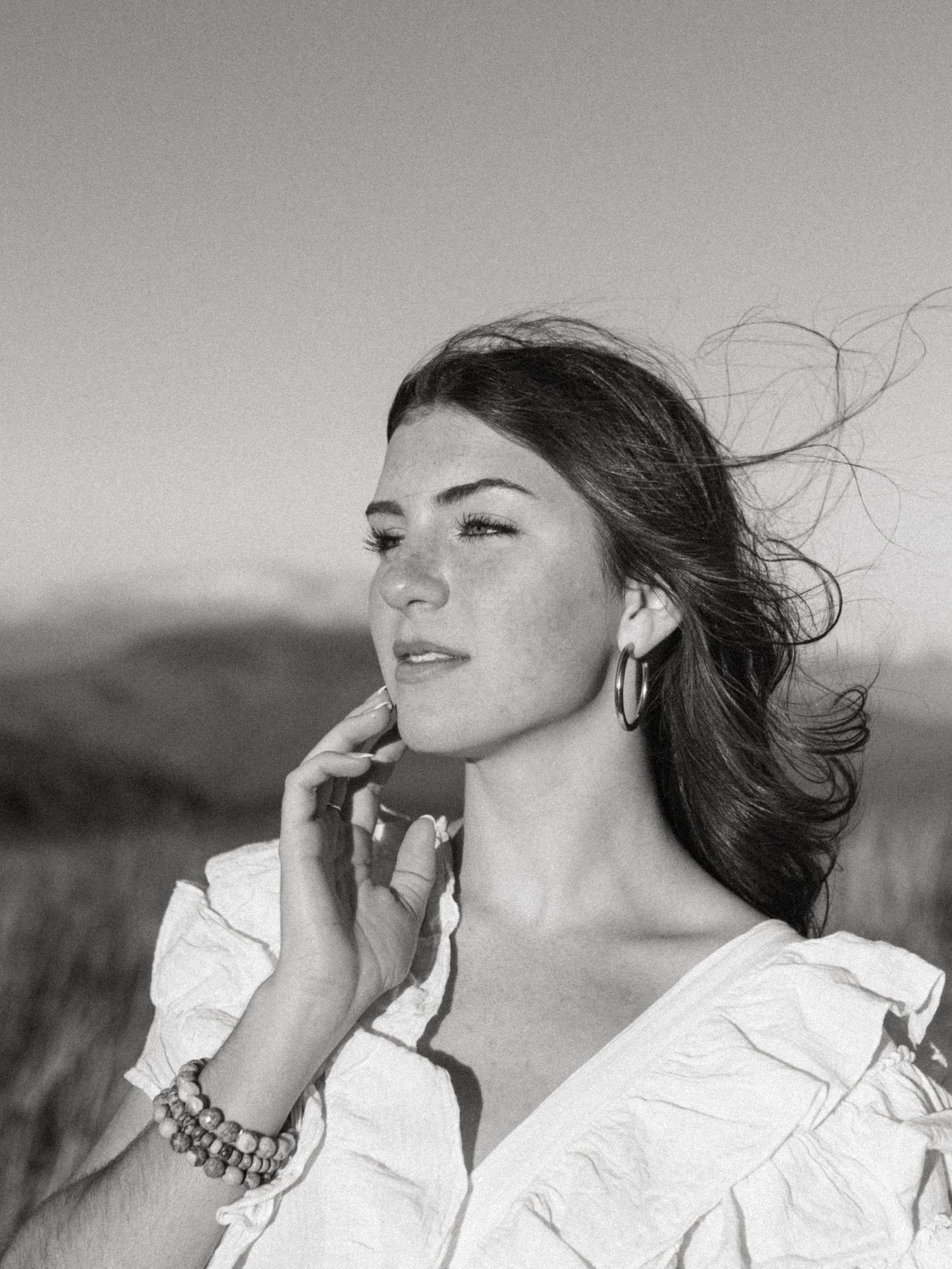 Black and white outdoor portrait by NYC branding photographer with windblown hair