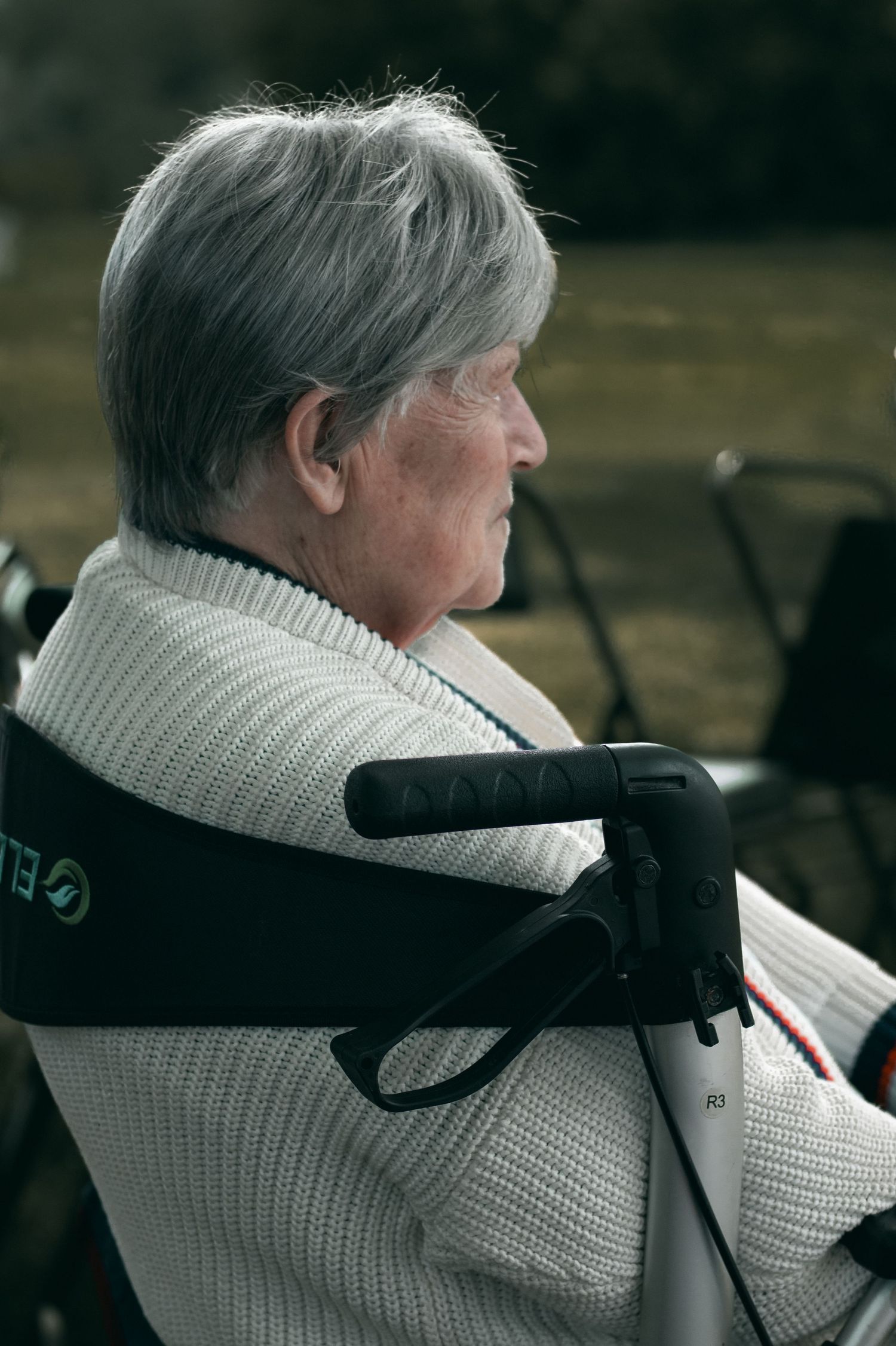 Close-up side view of someone wearing a white knit sweater with black stripes.