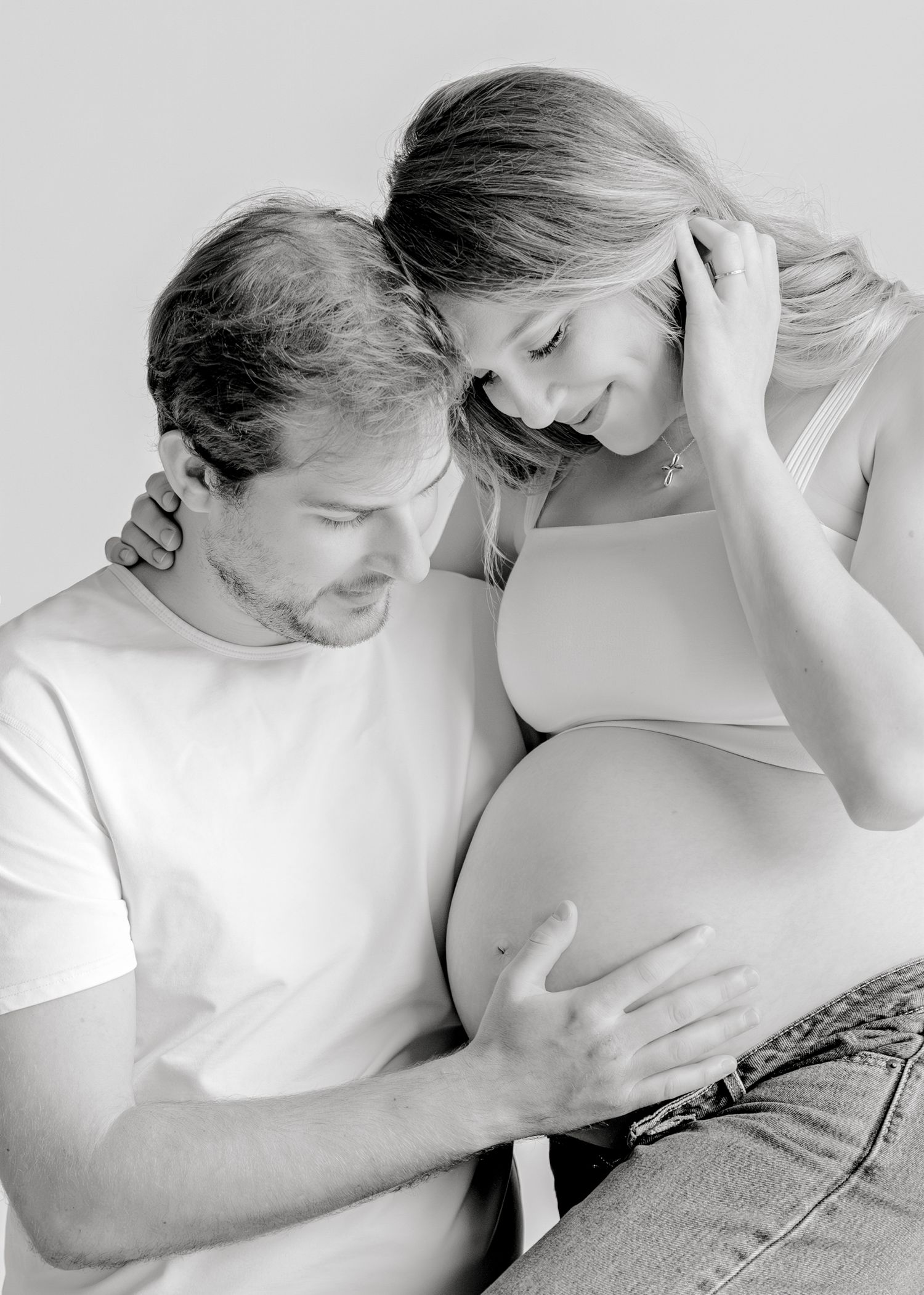 Four black and white artistic photographs showing intimate close up poses between two people in white clothing.