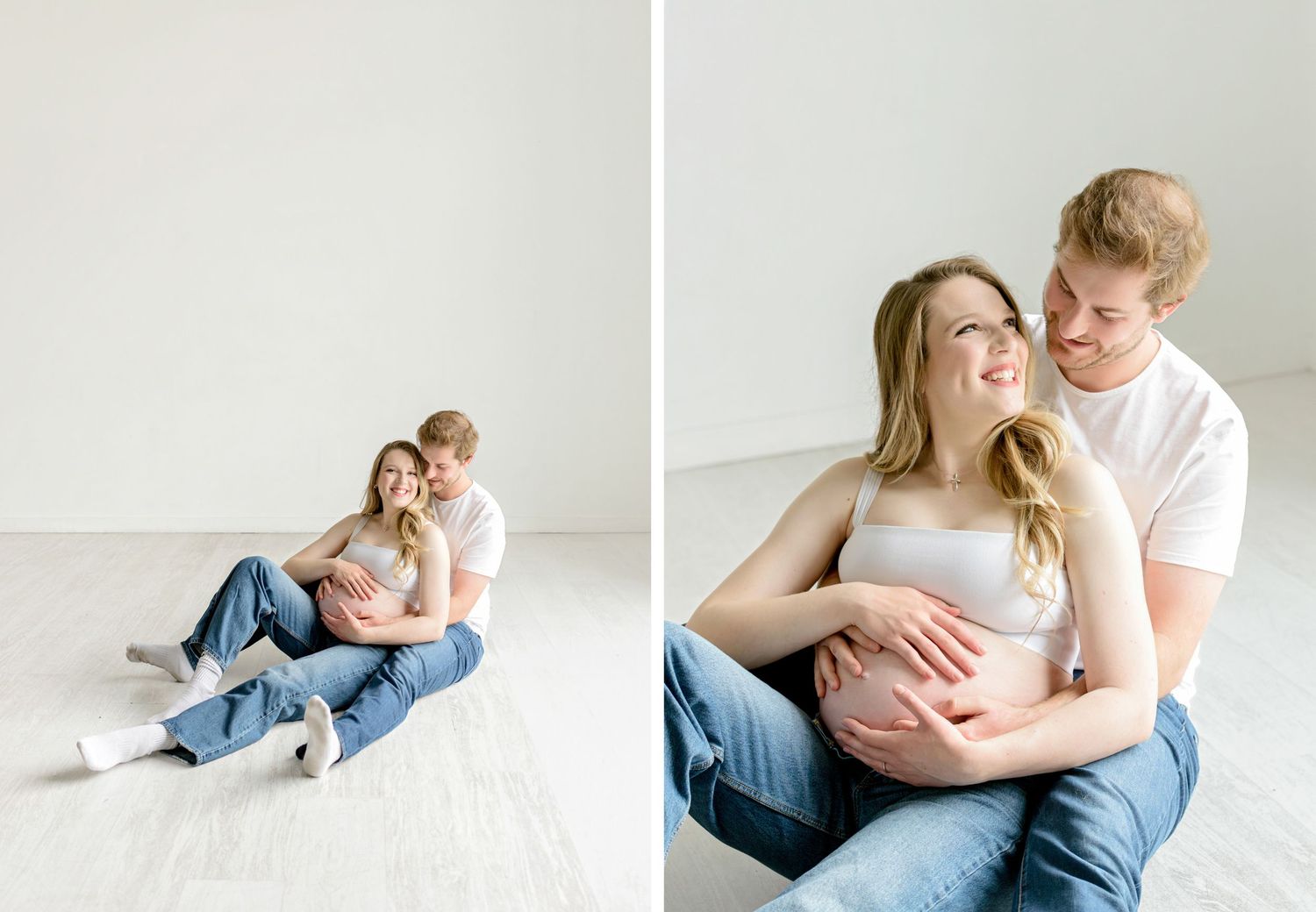 A couple wearing jeans and white tops share tender moments together in a minimalist white studio setting.