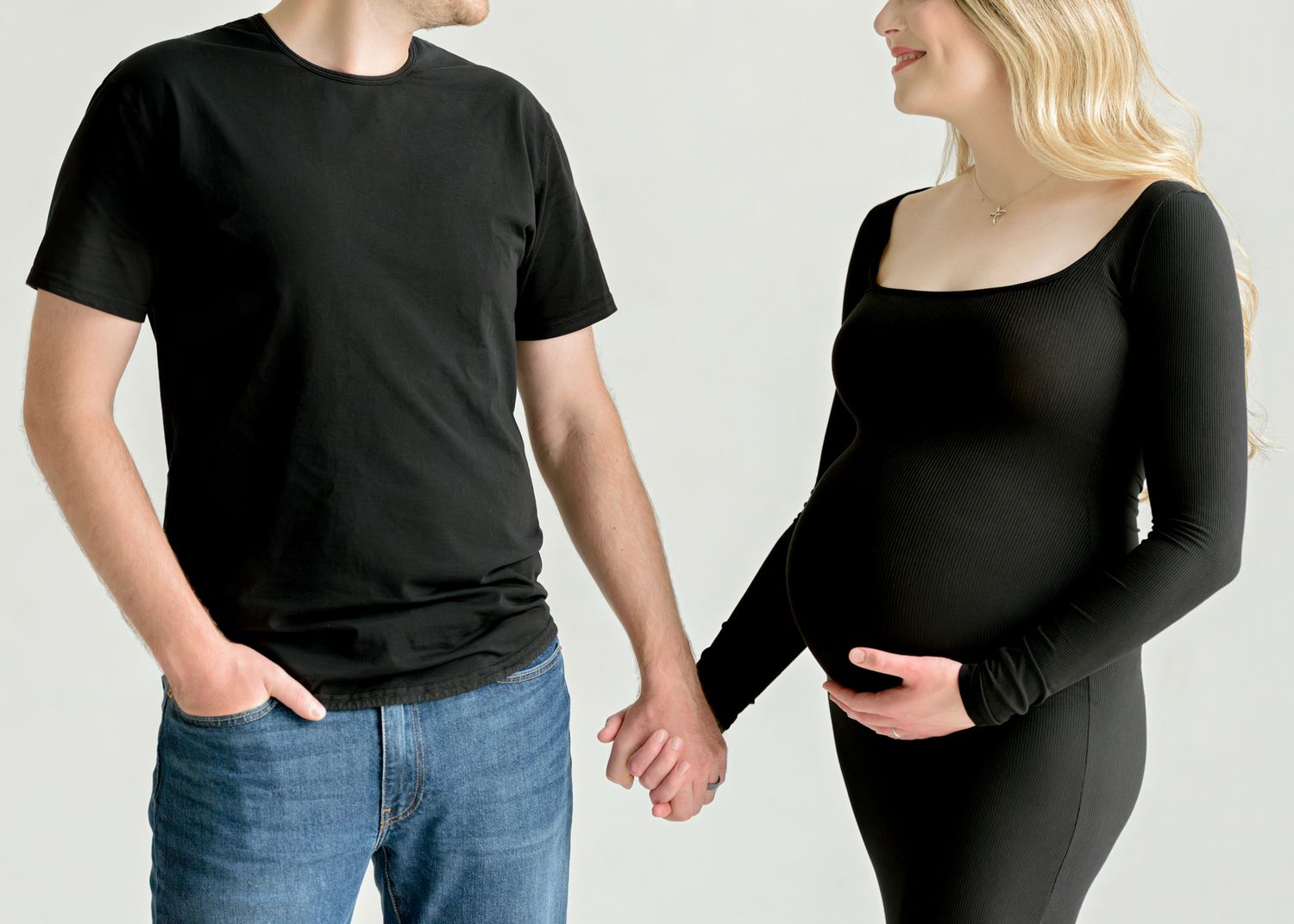 People dressed in black tops with jeans posing against a white background in different casual poses.
