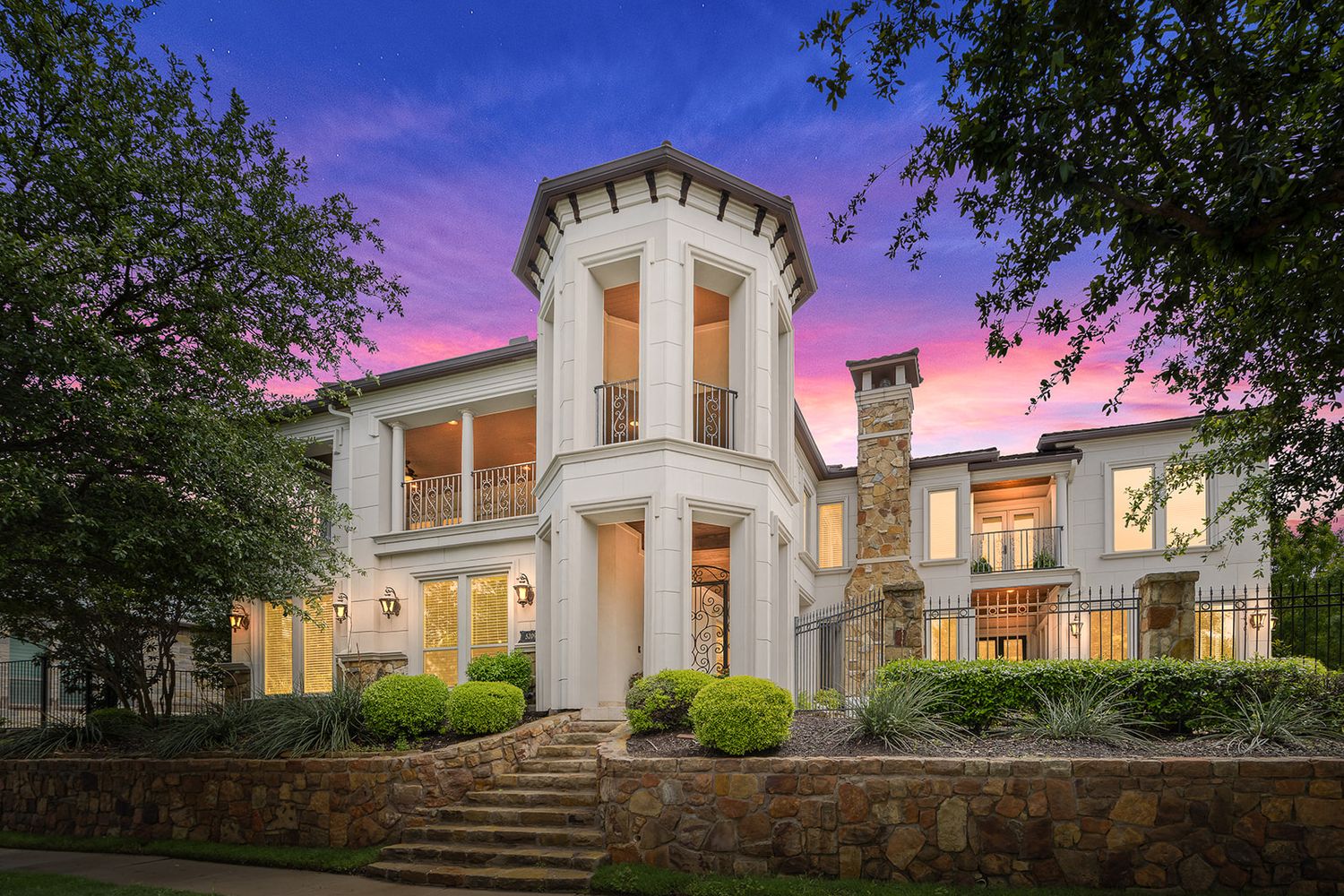 Majestic villa with white columns at dusk featuring multiple panoramic exterior views under a purple sky.