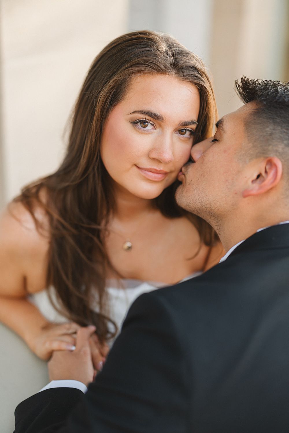 Romantic couple in formal wear share intimate moments during outdoor photography session.