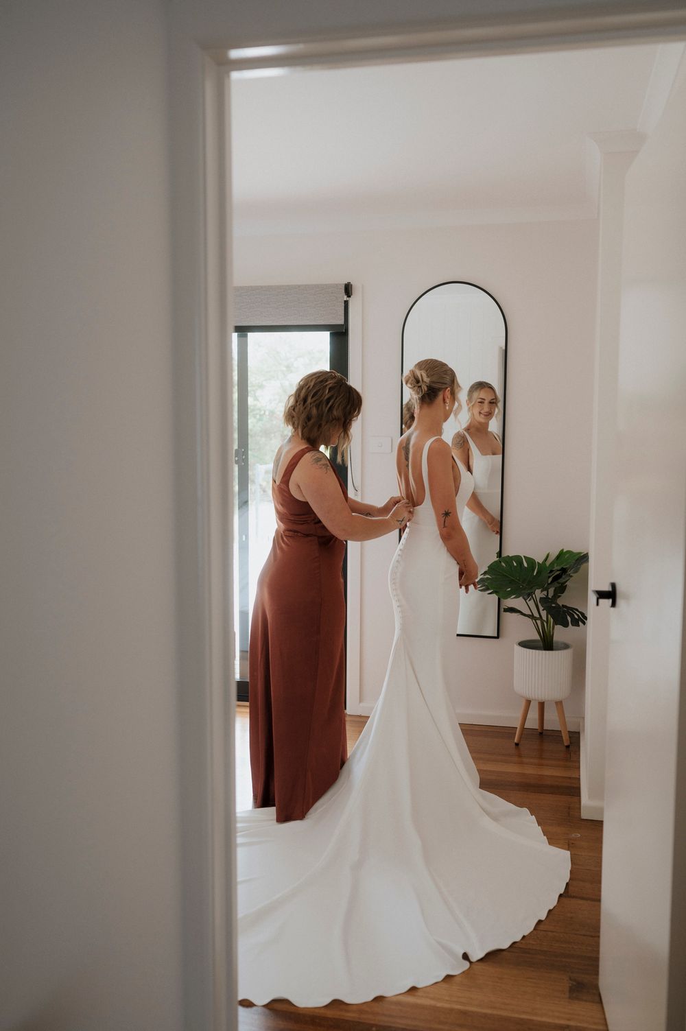 Wedding dress preparation scene in a bright modern room.