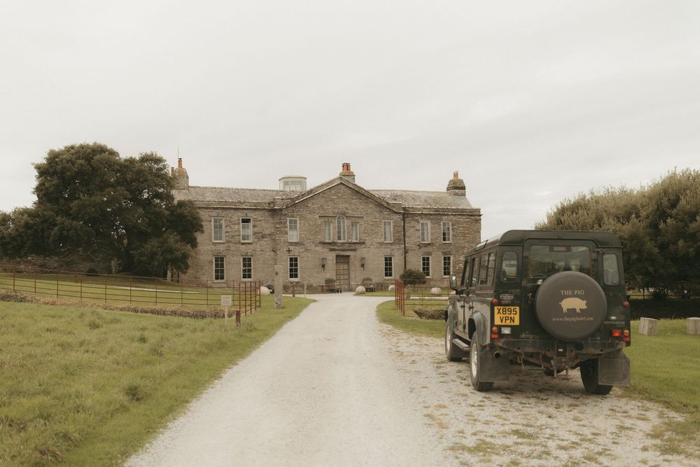 Panoramic view of a rustic stone manor house with surrounding countryside.