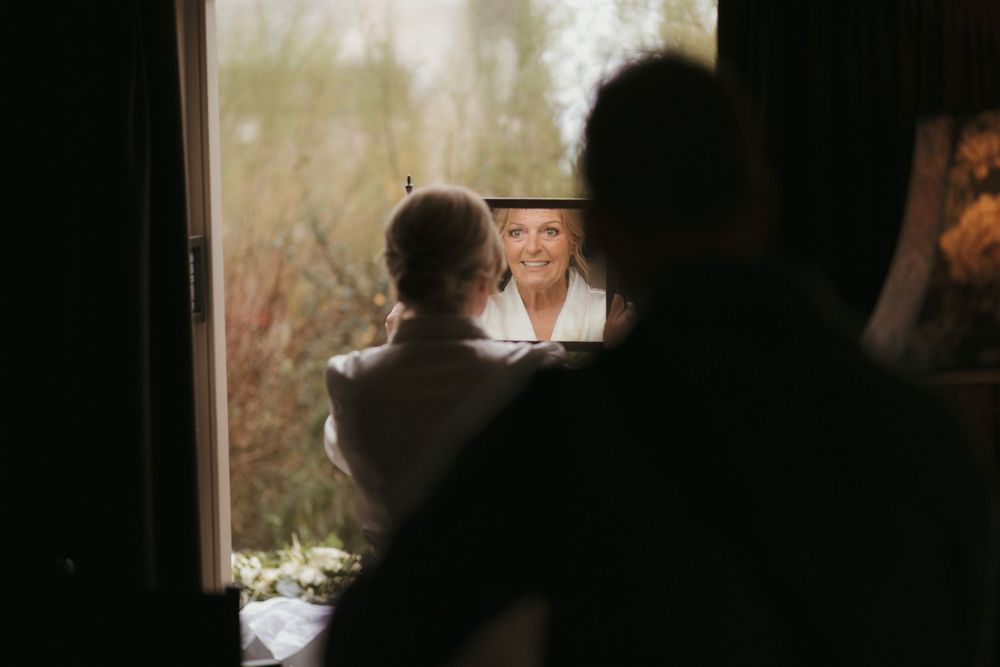 Artistic shot through window showing blurred figures in warm ambient lighting.