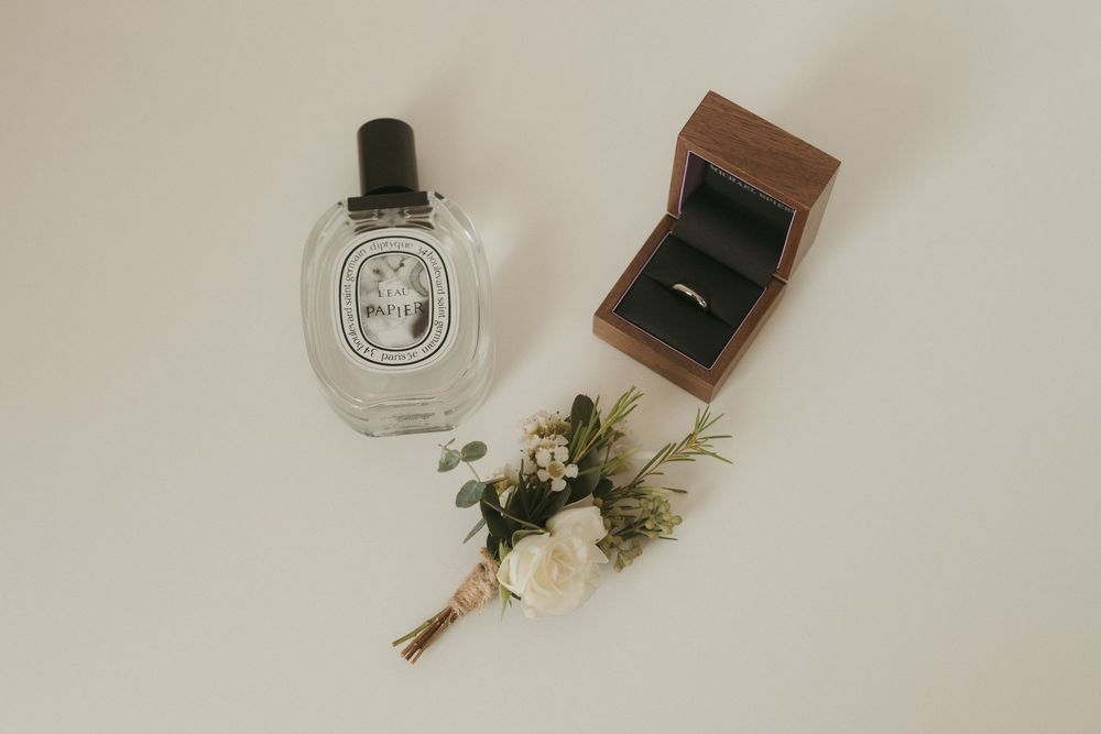 Elegant perfume bottles and vintage styling accessories arranged on white surface.