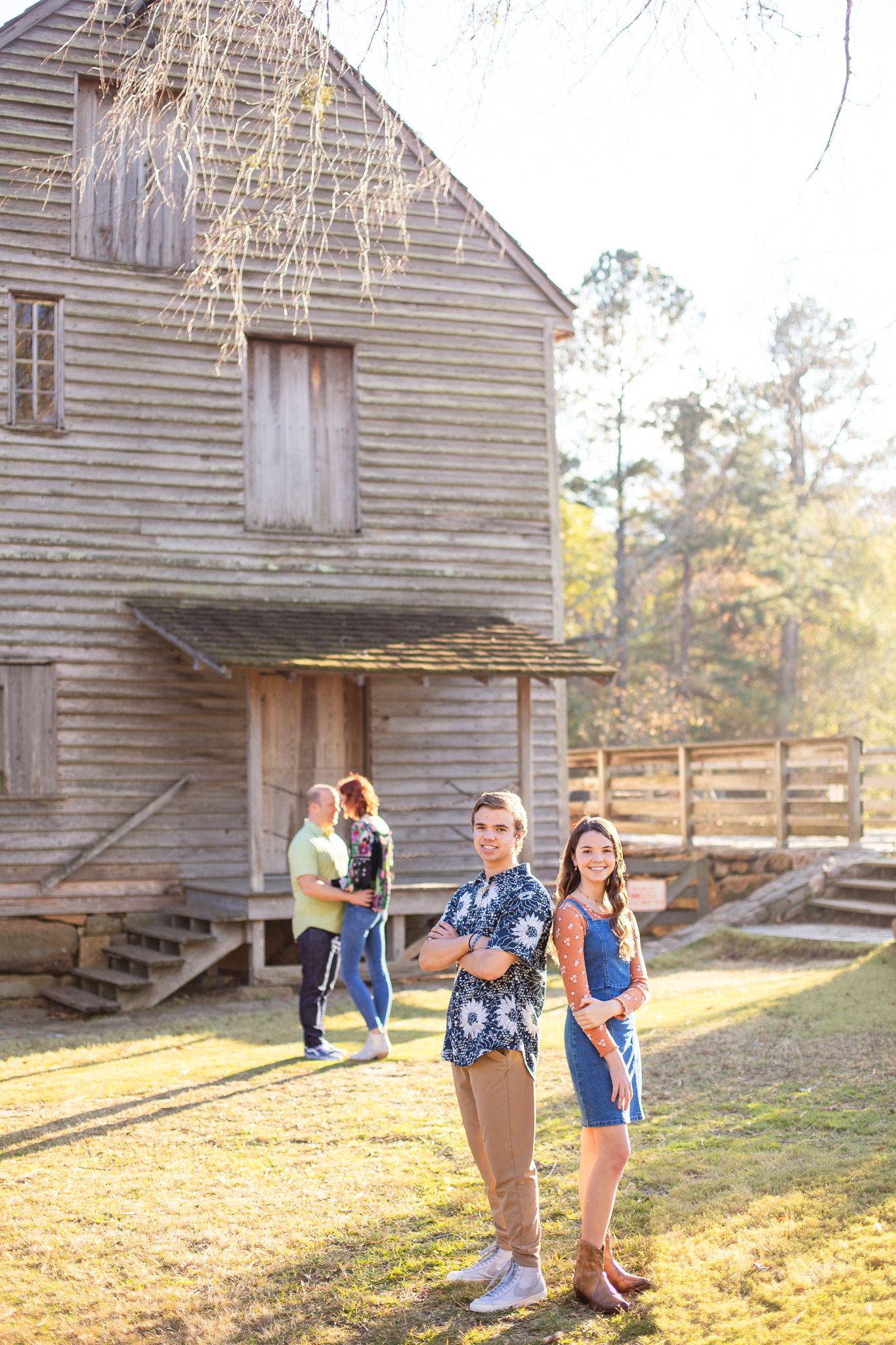 A Family posing and having fun near rustic wooden barn/mill at Yates mill