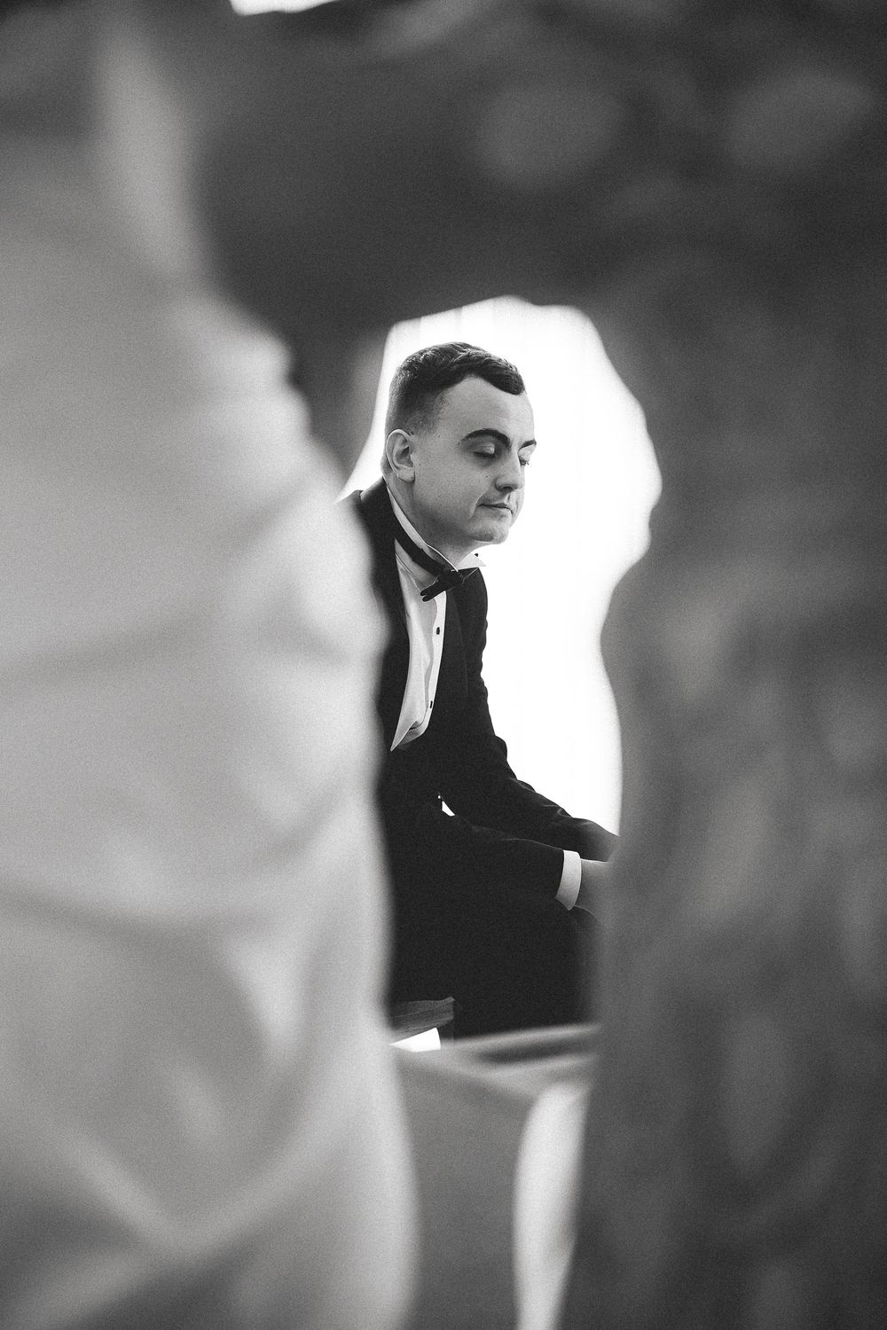 Black and white artistic portrait series showing a figure in dark clothing against a bright light source in a cinematic style.
