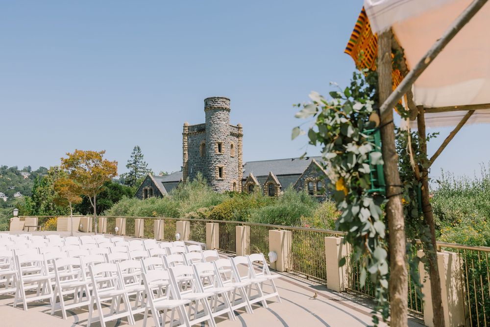 Outdoor ceremony setup at Geneva Terrace with rows of white chairs and castle-like tower in the background.