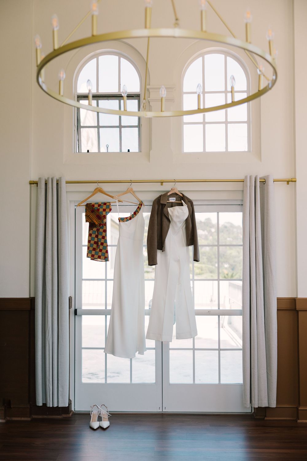 Wedding dress and suit hanging in a bright window at Geneva Terrace, ready for the couple to get dressed.