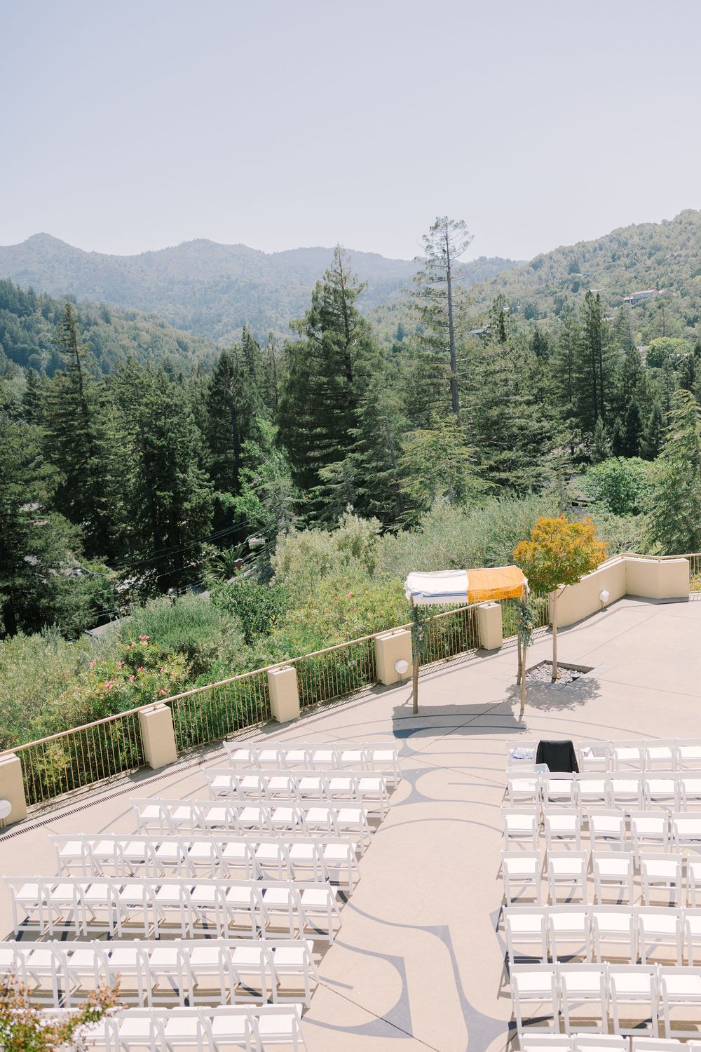 Aerial view of ceremony seating setup at Geneva Terrace, framed by lush greenery and distant mountains.