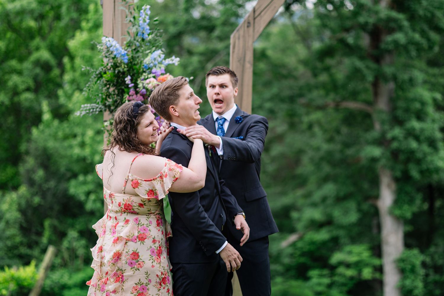 Couple twirling and laughing together during romantic dance surrounded by green trees on sunny afternoon.