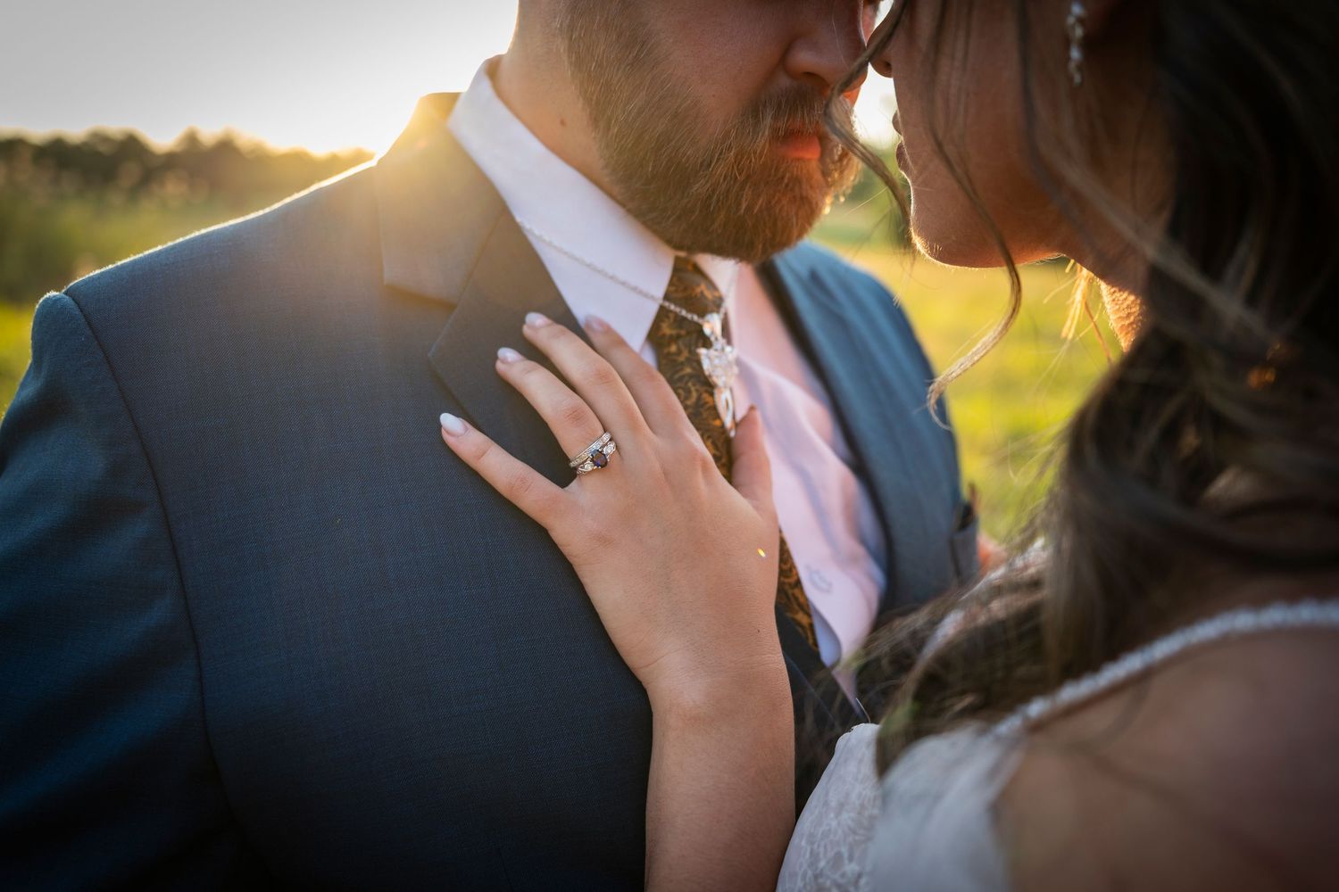 A couple shares an intimate sunset moment in their wedding attire, photographer capturing golden hour lighting effect.