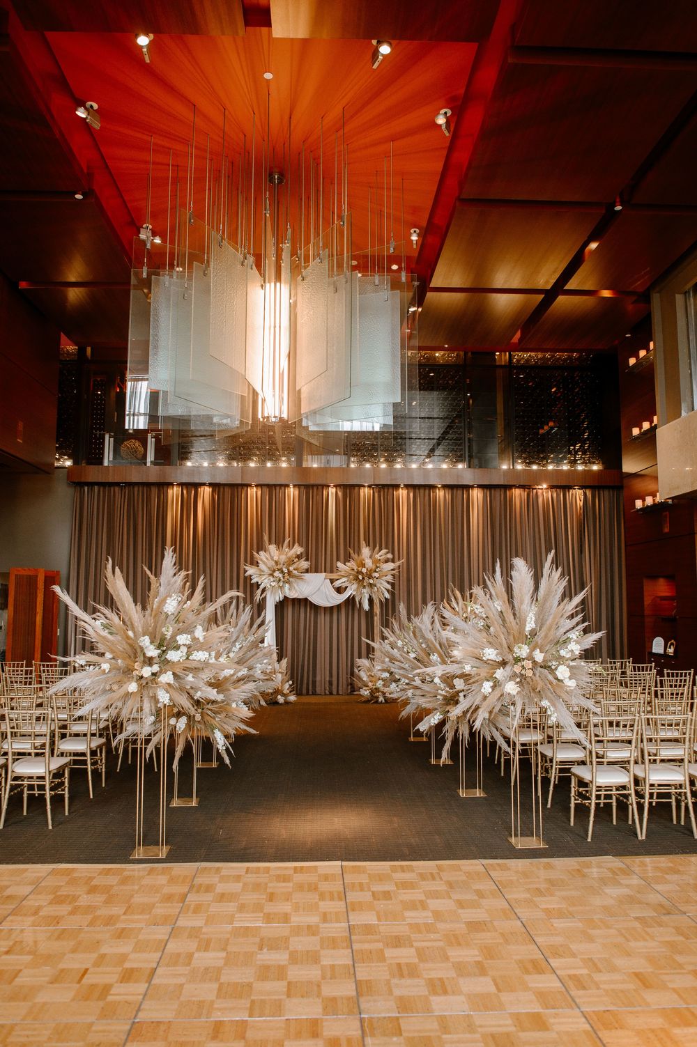 Modern banquet hall with white chairs and striking starburst decorations suspended over dining tables.