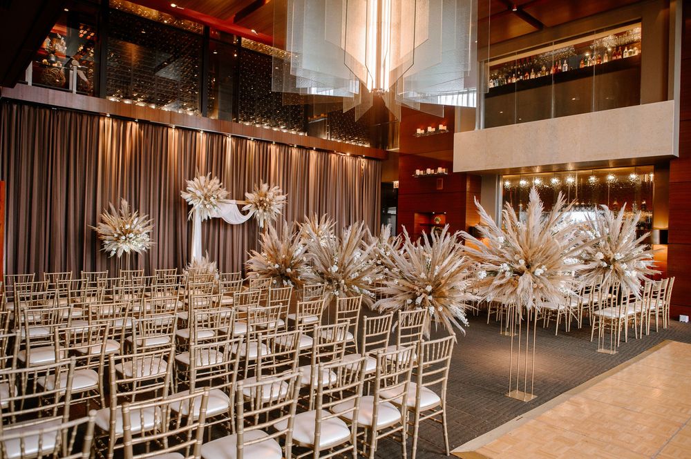 Modern event space with rows of silver ballroom chairs and dramatic starlight-style chandeliers hanging from the ceiling.