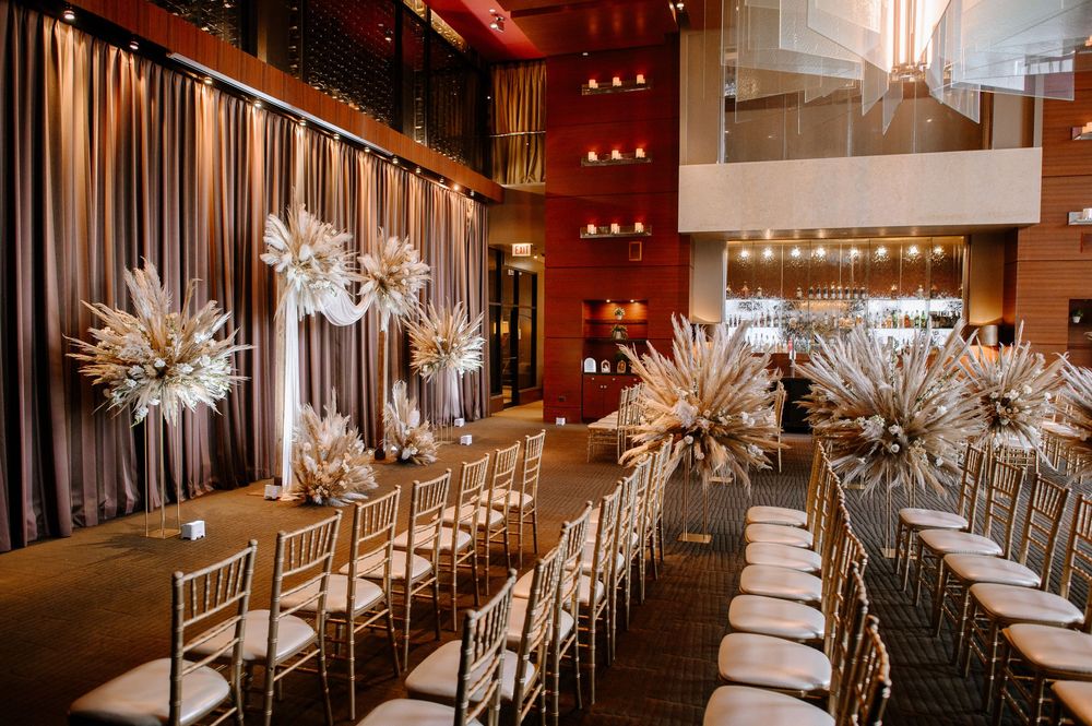 Modern wedding reception venue with white floral centerpieces and long tables set for an elegant dinner celebration.