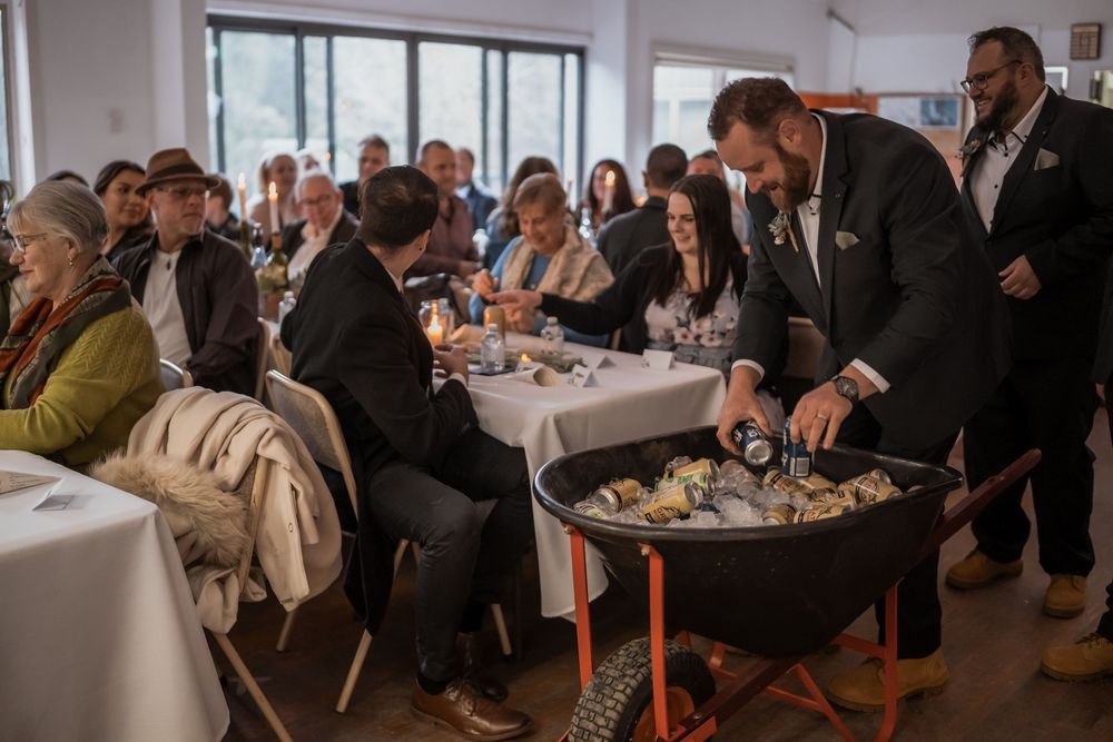 Guests sit at tables while a server tends to an ice bucket at an upscale dining event.