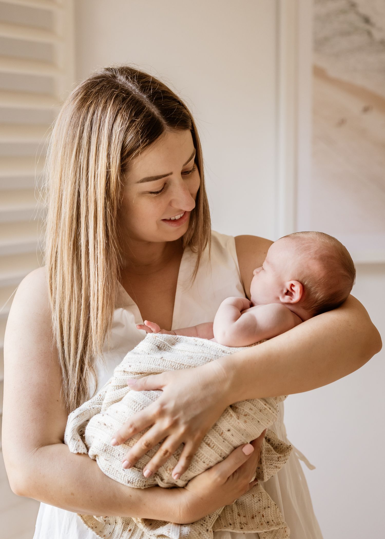 Baby wrapped in neutral blanket, photographed naturally in family’s living room in St Ives
