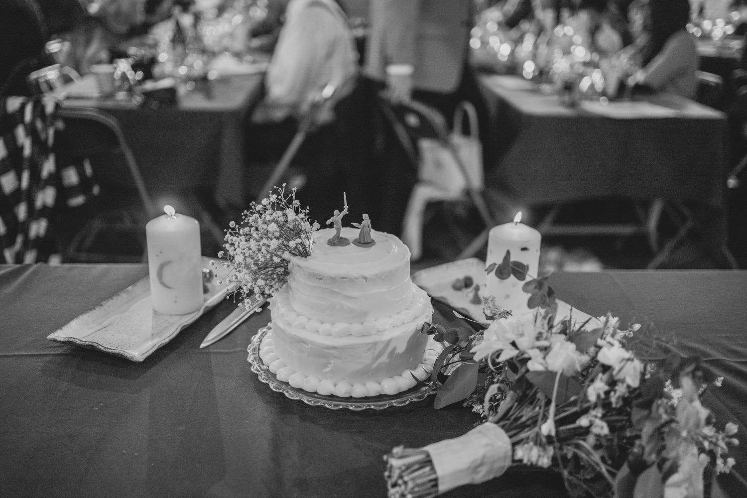 A beautiful wedding reception table setting with elegant white floral centerpieces and candlelight decor.