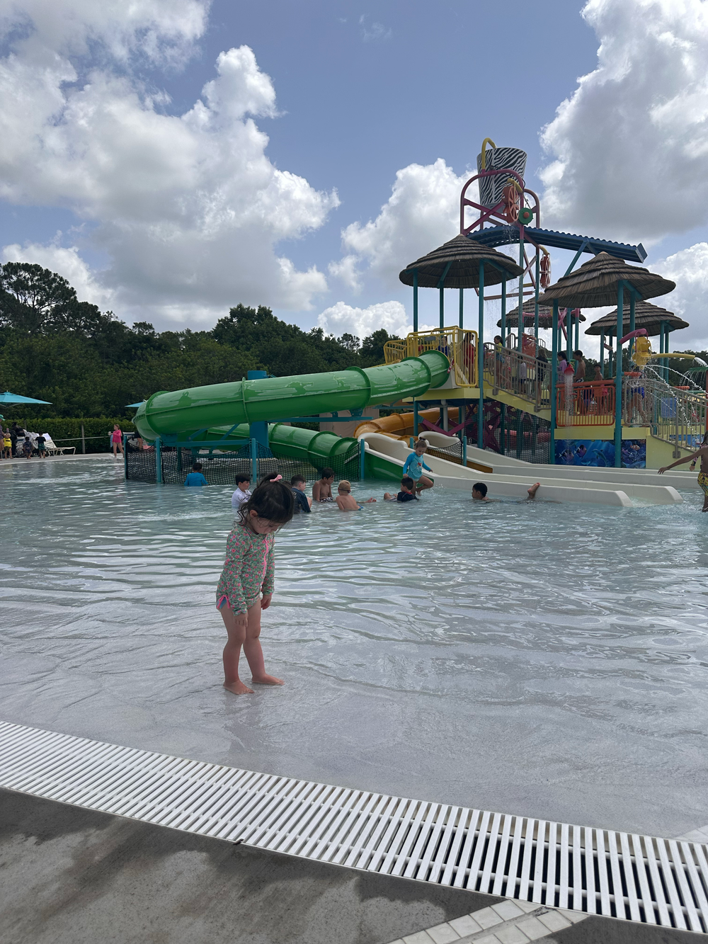 Giant colorful water slides and pool equipment at a water park on an overcast day.