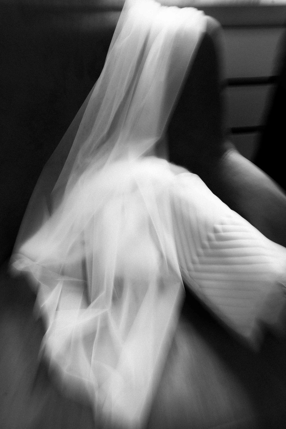 Abstract motion blur shots of white wedding dress creating ethereal effect.
