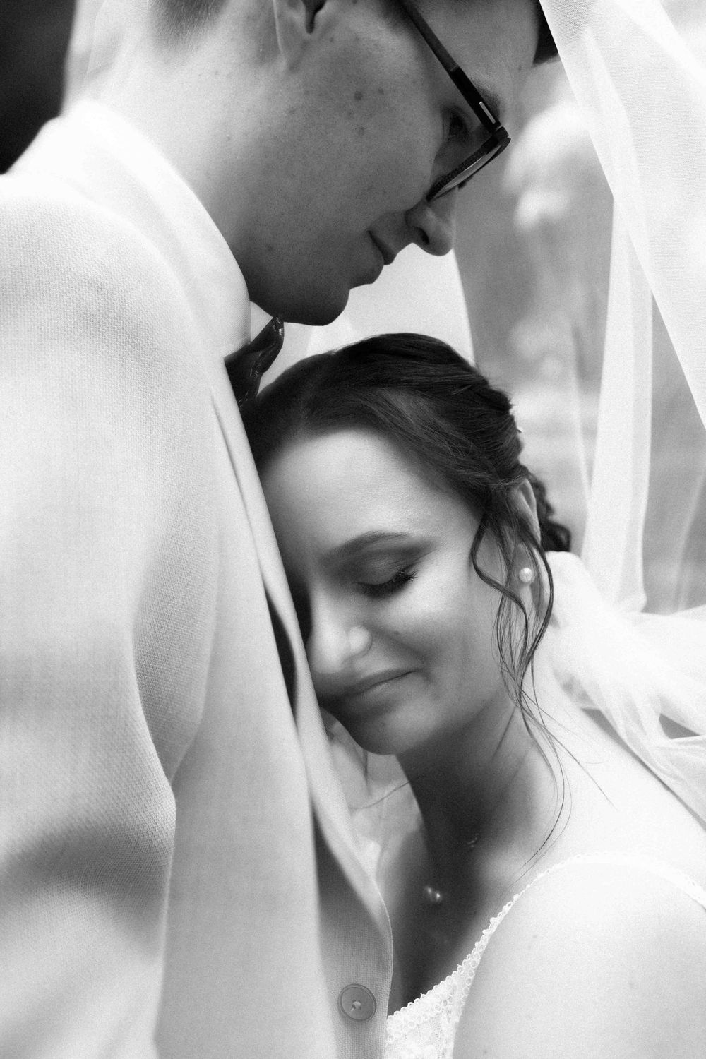 Black and white intimate portrait of tender wedding moment.