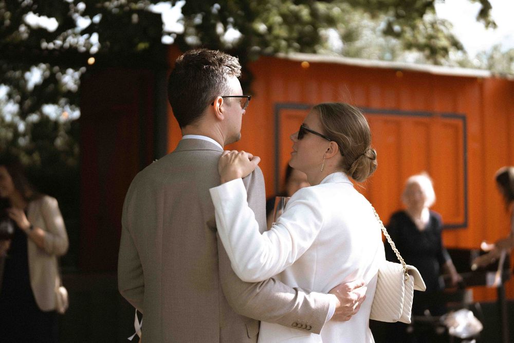 A couple shares their first dance at an outdoor wedding reception.