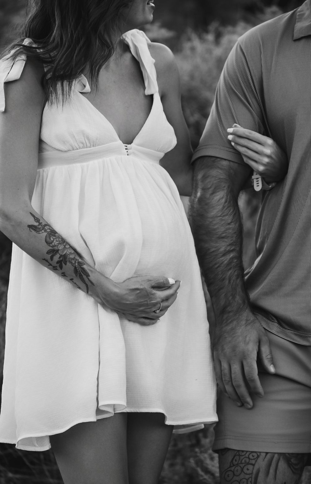 A series of black and white close-up photos showing a couple embracing in casual summer attire.