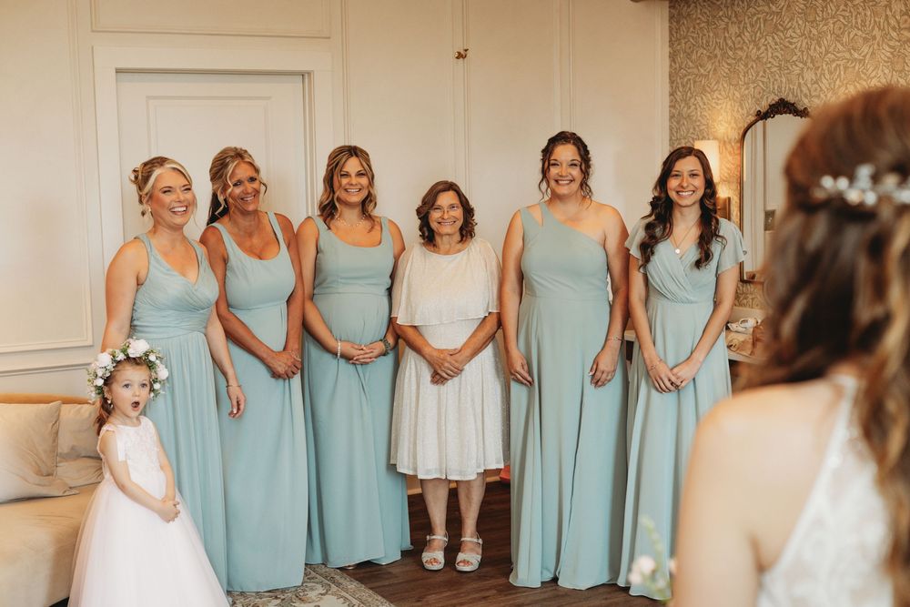Bridesmaids in matching light blue dresses standing together in a row.