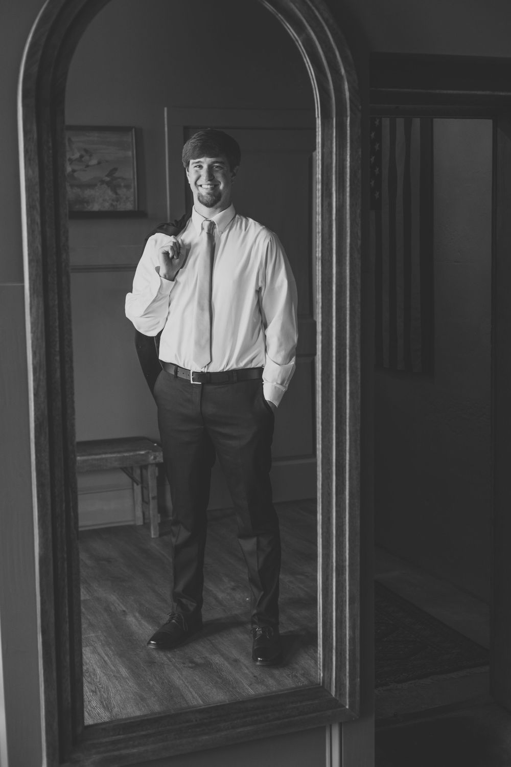 Classic black and white portrait with arched mirror reflections and formal attire.