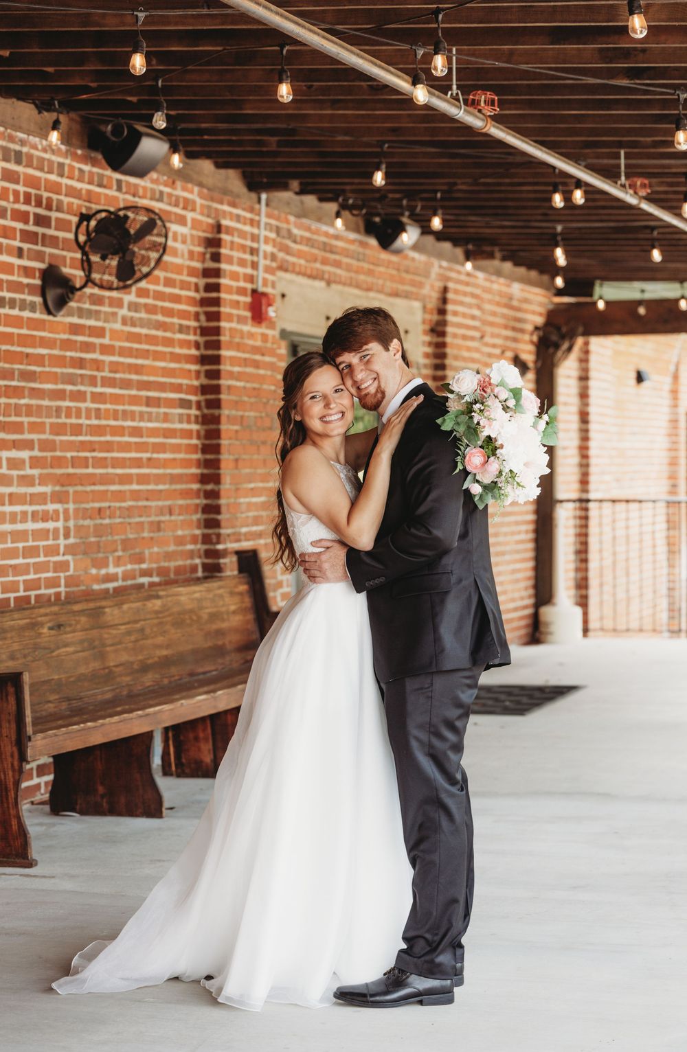A romantic wedding dance sequence showing a couple in a rustic brick venue with exposed wooden beams.